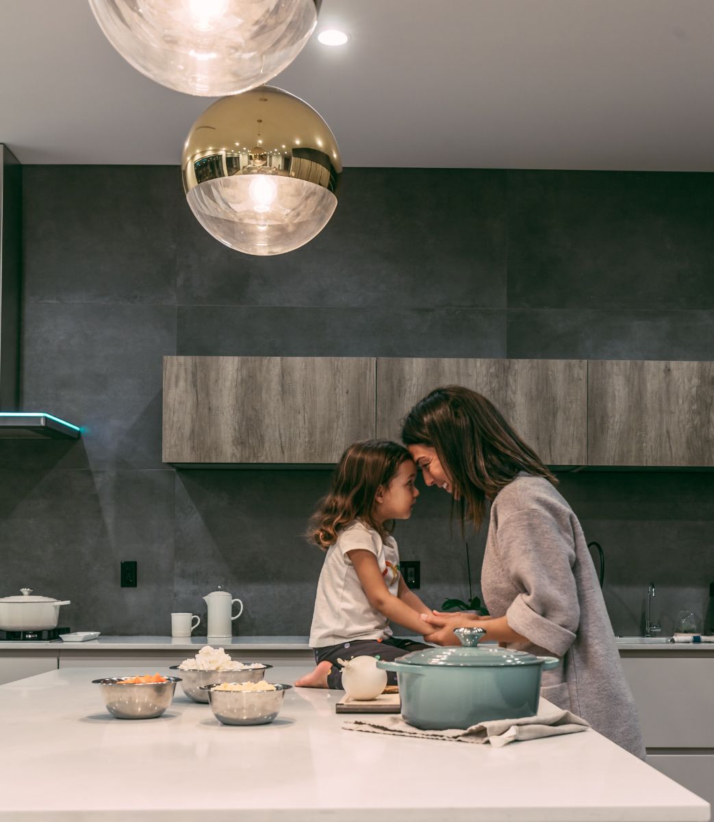 Woman sitting with child in kitchen of home_kylecoats